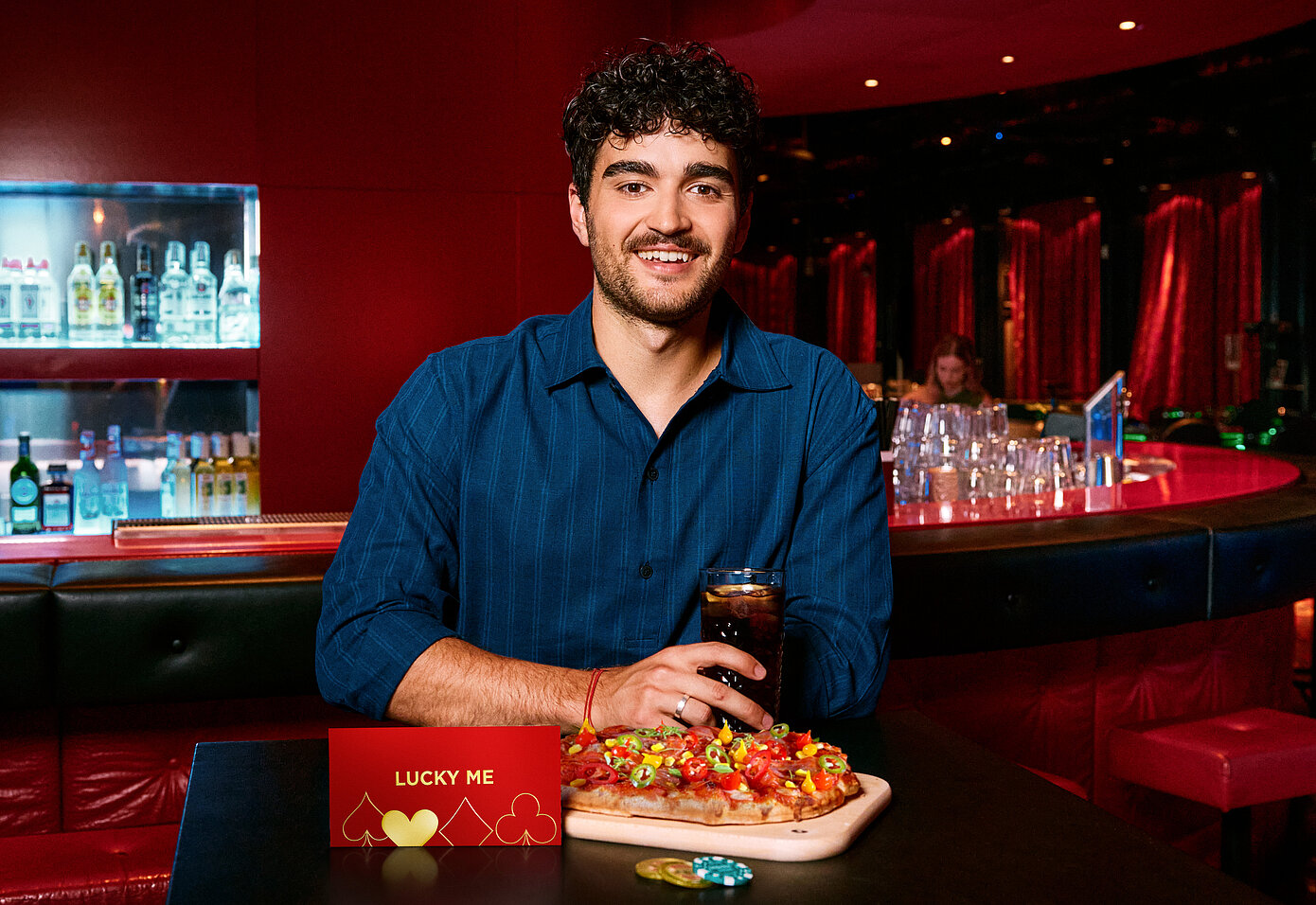 Mann an der Casino Bar mit Lucky Me Gutschein, Pinsa und Cola
