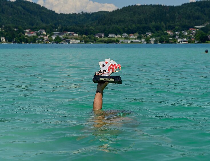Poker EM 2025 Sujet Hand mit Pokal im Wörthersee