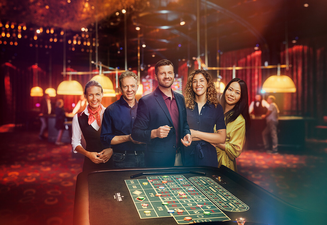 Croupière und Gäste-Gruppe stehen vor Roulette-Tisch