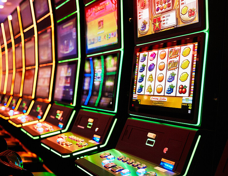 Nahaufnahme von Spielautomaten die in einer Reihe aufgestellt sind
