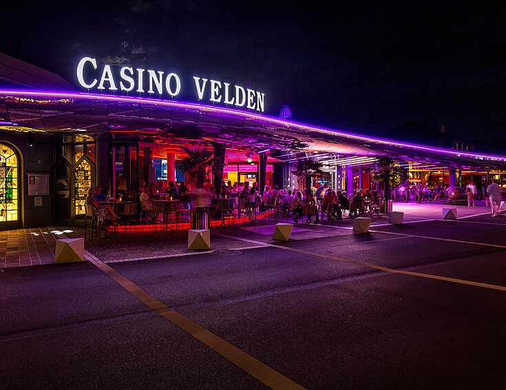 Casino Velden Außenansicht bei Nacht mit violetter Beleuchtung