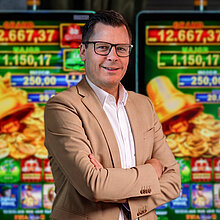 Key Account Manager im Casino Salzburg in hellem Anzug vor Spielautomaten