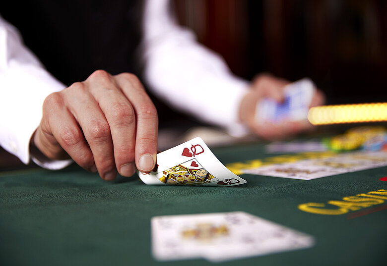 Croupier deckt Karten am Poker Tisch auf